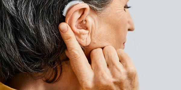 Hearing aid behind the ear of senior woman, close-up